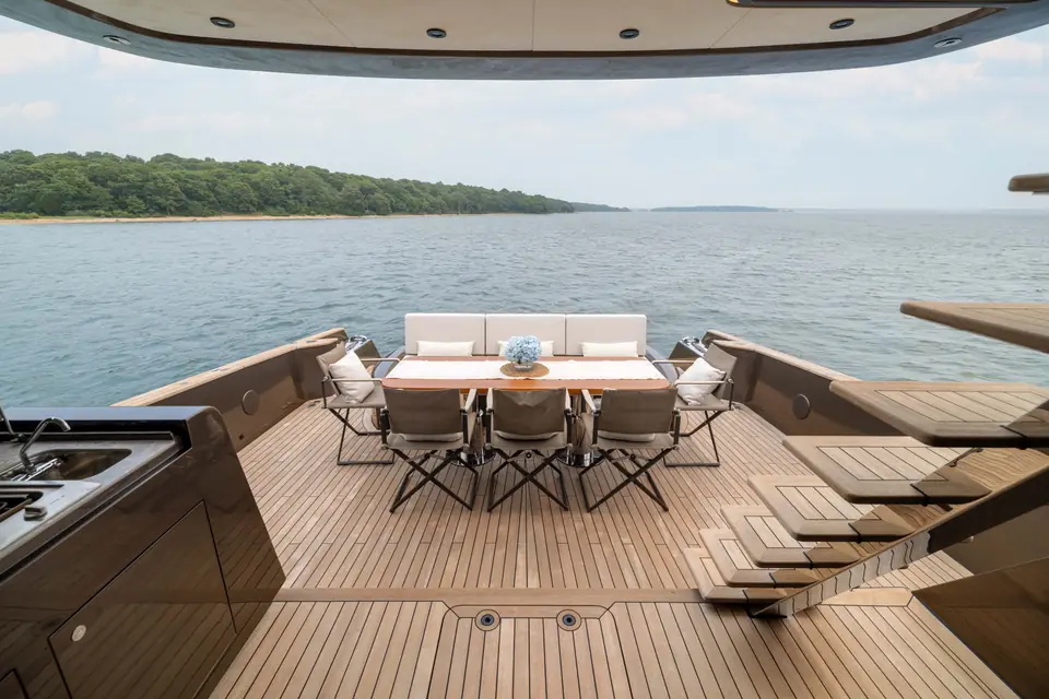 The cockpit dining table set for six, shade overhead, water immediately astern.
