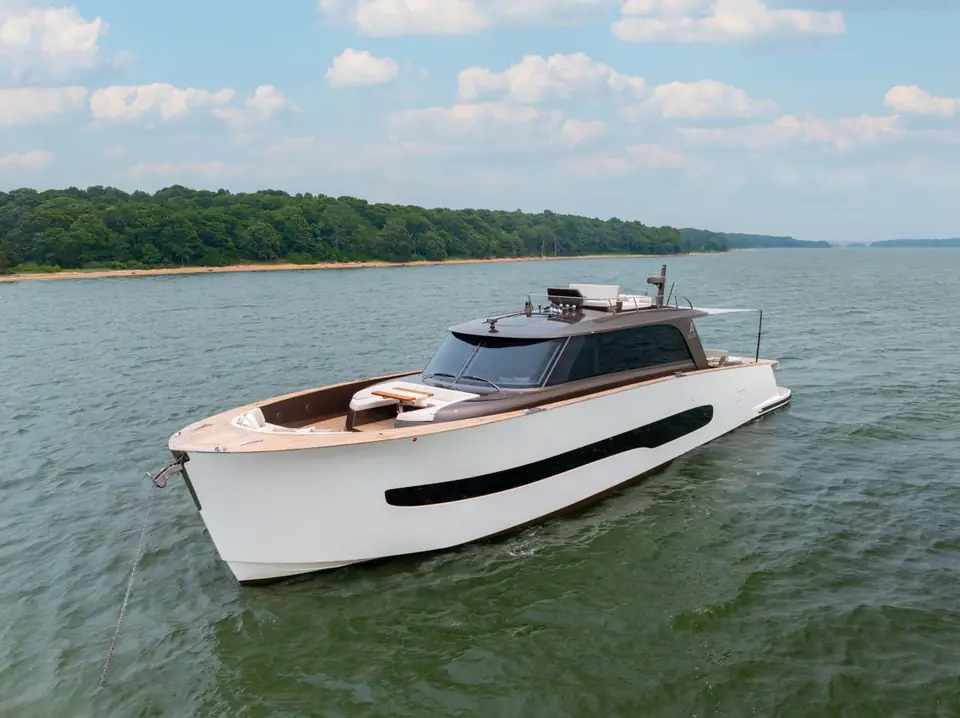 The foredeck from above: sunbed forward of the windshield, teak laid fore and aft, ground tackle stowed.
