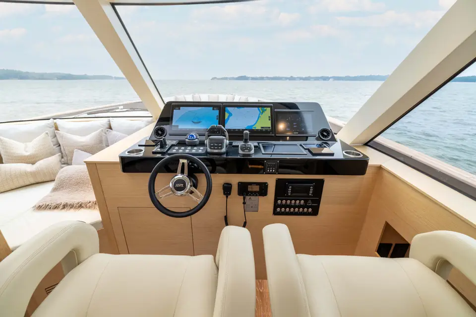The lower helm: displays set flush in the console, wheel and throttles, windshield beyond.