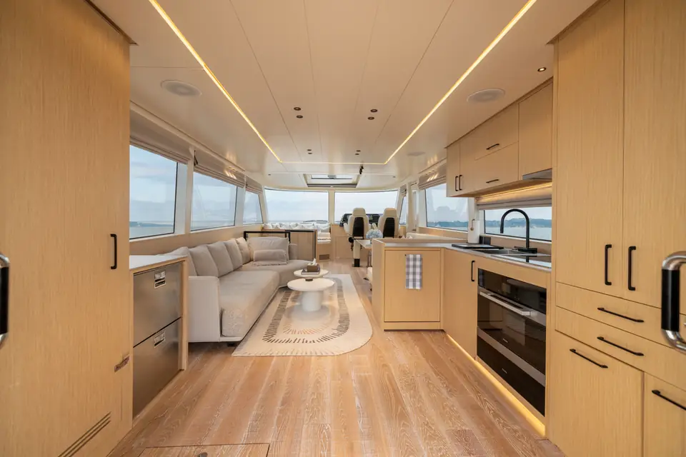 The salon looking forward to the lower helm, window band unbroken along both sides.